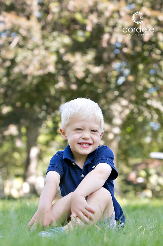 Little boy sitting on grass together