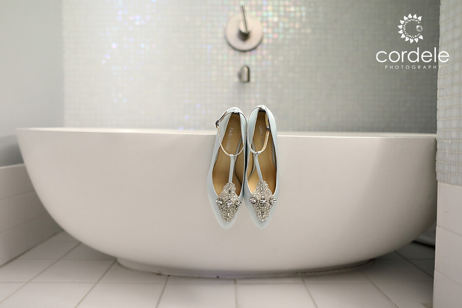 Light blue shoes hanging on bathrub